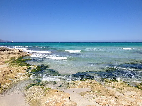 Im Vordergrund Felsen im Hintergrund der Blick auf das freie Meer